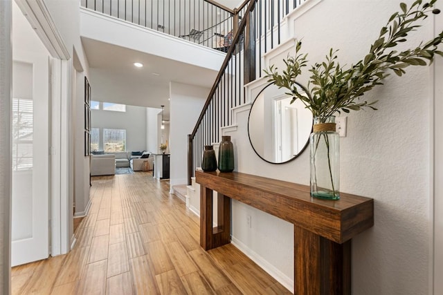 707 Sugar Cane Rd, Buda, TX 78610 - foyer entrance with stairway, a high ceiling, light wood finished floors, baseboards, and recessed lighting
