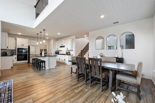 707 Sugar Cane Rd, Buda, TX 78610 - dining area featuring light wood-style floors, recessed lighting, stairs, and baseboards