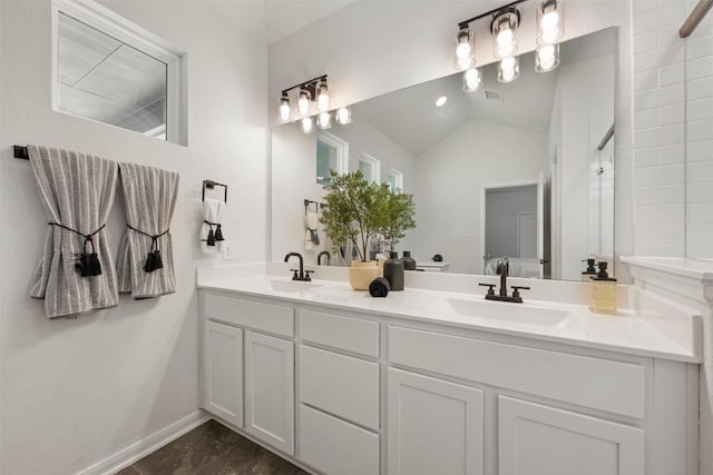 707 Sugar Cane Rd, Buda, TX 78610 - bathroom featuring double vanity, baseboards, and vaulted ceiling
