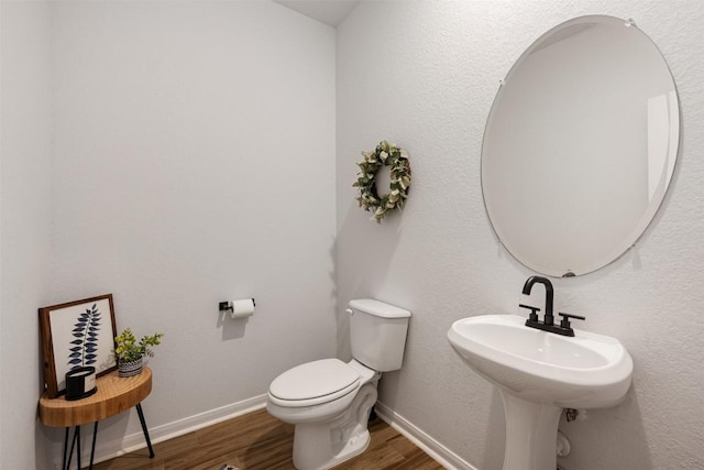 707 Sugar Cane Rd, Buda, TX 78610 - bathroom with wood finished floors, toilet, baseboards, and a sink