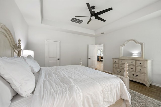 707 Sugar Cane Rd, Buda, TX 78610 - bedroom with a raised ceiling, wood finished floors, baseboards, and ceiling fan