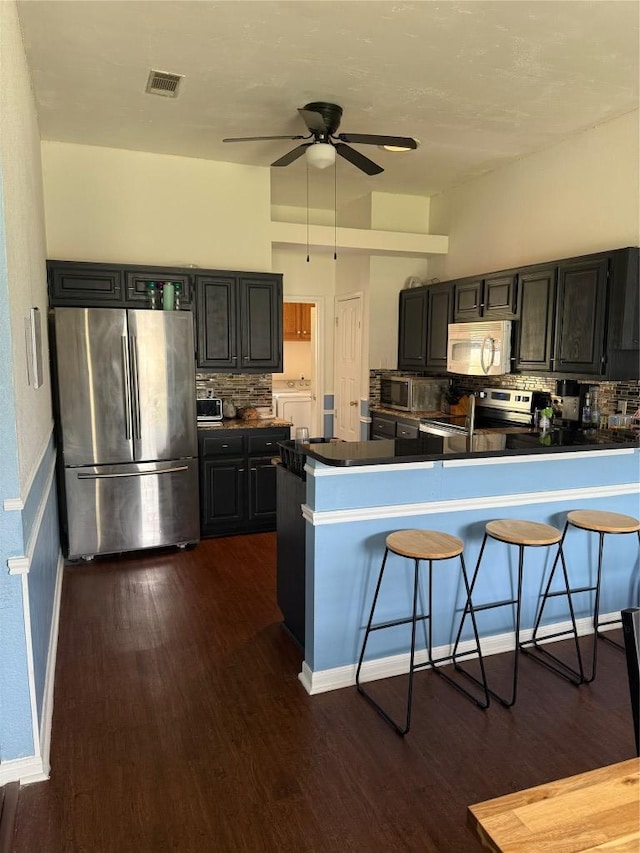 907 Vernon Dr, Copperas Cove, TX 76522 - kitchen with appliances with stainless steel finishes, backsplash, dark wood-style flooring, and ceiling fan