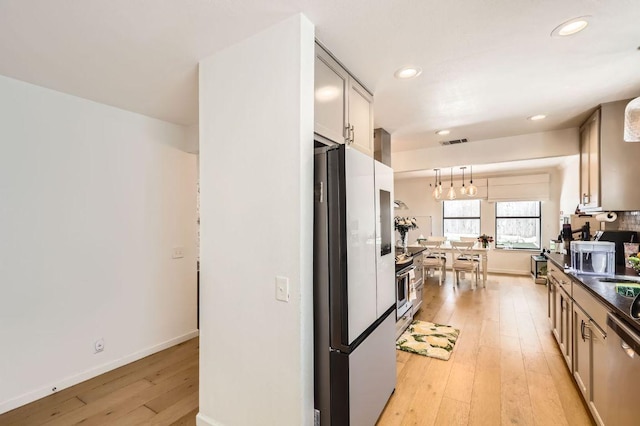 9518 Topridge Dr Unit 7, Austin, TX 78750 - kitchen with freestanding refrigerator, light wood-style floors, dark countertops, a chandelier, and recessed lighting