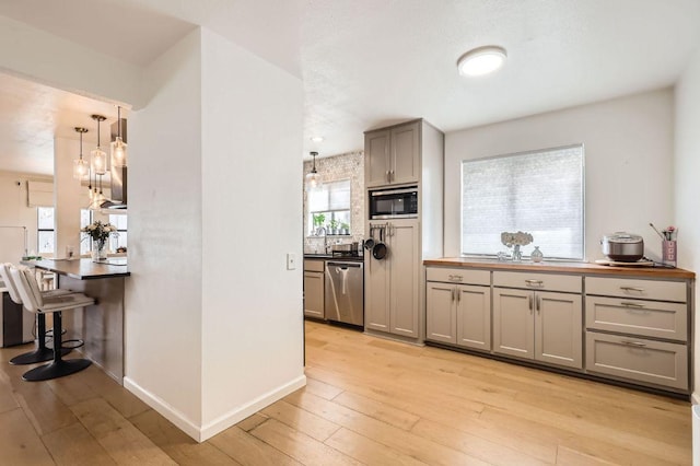 9518 Topridge Dr Unit 7, Austin, TX 78750 - kitchen featuring black microwave, stainless steel dishwasher, light wood-style flooring, gray cabinets, and hanging light fixtures