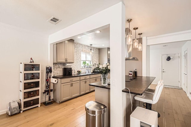 9518 Topridge Dr Unit 7, Austin, TX 78750 - kitchen with dark countertops, gray cabinetry, light wood finished floors, and a kitchen bar