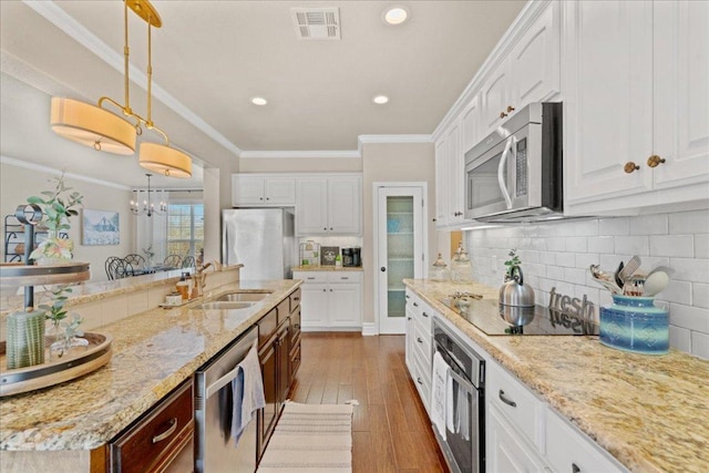 1409 Old Mill Rd, Salado, TX 76571 - kitchen featuring appliances with stainless steel finishes, white cabinets, backsplash, hardwood / wood-style flooring, and crown molding