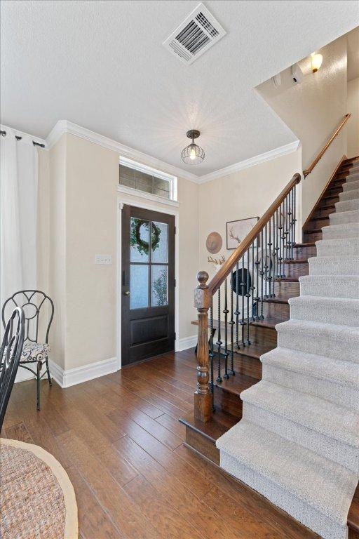 1409 Old Mill Rd, Salado, TX 76571 - foyer entrance featuring stairs, baseboards, crown molding, hardwood / wood-style floors, and a textured ceiling