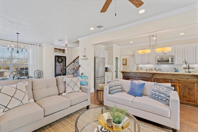 1409 Old Mill Rd, Salado, TX 76571 - living room featuring light wood-style floors, a ceiling fan, stairway, crown molding, and recessed lighting