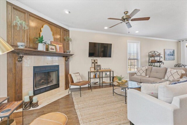 1409 Old Mill Rd, Salado, TX 76571 - living room featuring crown molding, a ceiling fan, a tile fireplace, wood finished floors, and recessed lighting