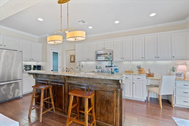 1409 Old Mill Rd, Salado, TX 76571 - kitchen featuring stainless steel appliances, white cabinets, ornamental molding, backsplash, and recessed lighting