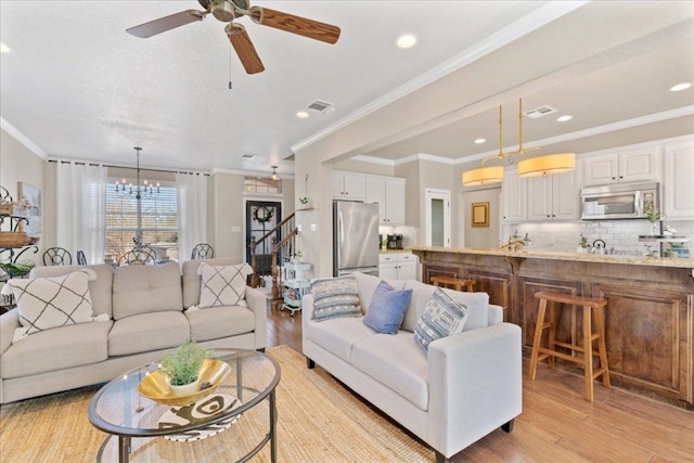 1409 Old Mill Rd, Salado, TX 76571 - living room featuring light wood finished floors, a chandelier, ceiling fan, recessed lighting, and crown molding