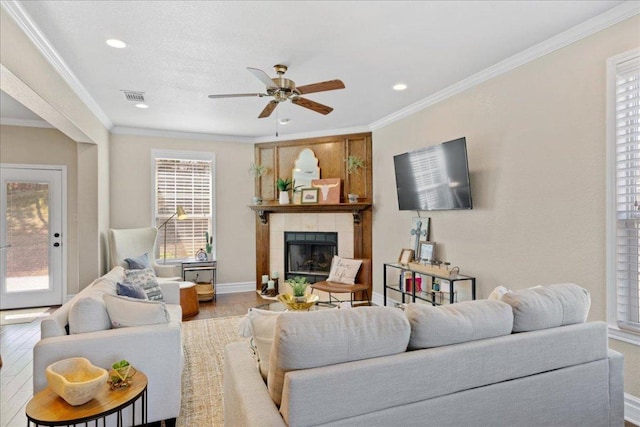 1409 Old Mill Rd, Salado, TX 76571 - living room with a ceiling fan, a fireplace, ornamental molding, wood finished floors, and recessed lighting