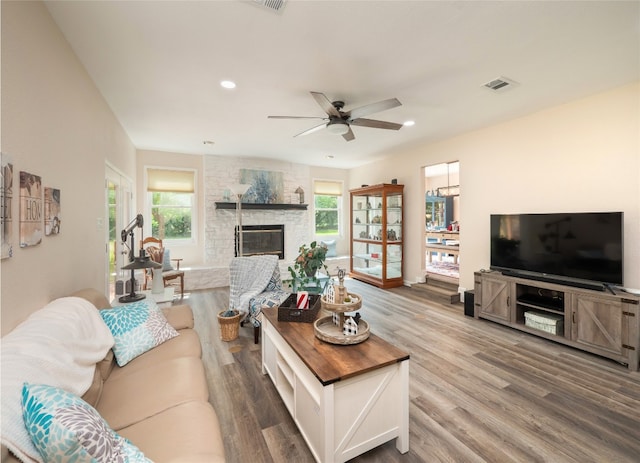 2702 Double Tree St, Round Rock, TX 78681 - living room with wood finished floors, ceiling fan, a stone fireplace, and recessed lighting