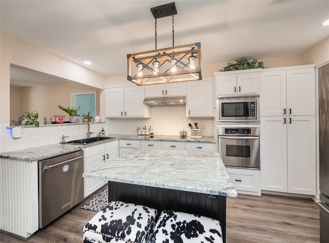 2702 Double Tree St, Round Rock, TX 78681 - kitchen featuring stainless steel appliances, a sink, white cabinets, backsplash, and under cabinet range hood