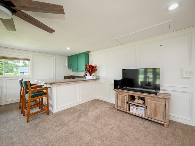 2702 Double Tree St, Round Rock, TX 78681 - kitchen with a decorative wall, light colored carpet, green cabinetry, a peninsula, and ceiling fan