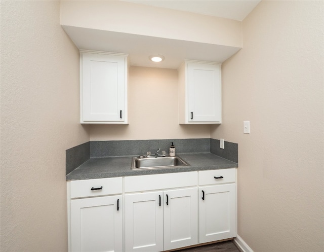 2702 Double Tree St, Round Rock, TX 78681 - kitchen with dark countertops, a sink, and white cabinetry