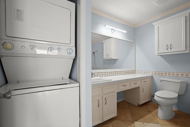 2450 Wickersham Ln Unit M1318, Austin, TX 78741 - washroom featuring stacked washer / drying machine, ornamental molding, light tile patterned floors, a wainscoted wall, and tile walls