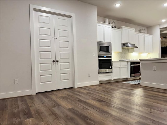 1162 Thicket Ln, New Braunfels, TX 78132 - kitchen with stainless steel appliances, under cabinet range hood, baseboards, dark wood-type flooring, and white cabinets