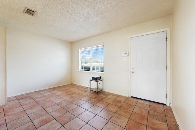 105 E St Johns Ave, Austin, TX 78752 - entrance foyer with a textured ceiling, light tile patterned floors, and baseboards