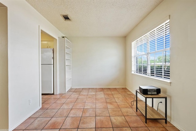105 E St Johns Ave, Austin, TX 78752 - empty room featuring a textured ceiling and light tile patterned floors