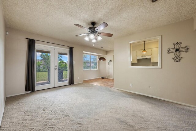 105 E St Johns Ave, Austin, TX 78752 - carpeted empty room featuring a ceiling fan, baseboards, french doors, and a textured ceiling