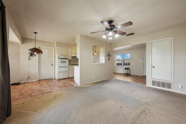 105 E St Johns Ave, Austin, TX 78752 - unfurnished living room with a ceiling fan, light tile patterned floors, a textured ceiling, and baseboards