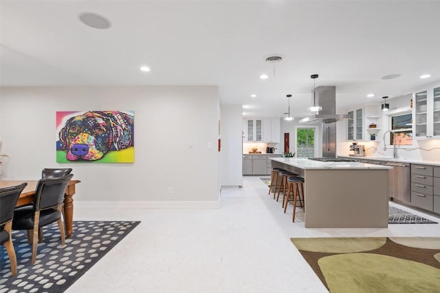 1254 S Church St, Georgetown, TX 78626 - kitchen featuring appliances with stainless steel finishes, island range hood, a kitchen island, a breakfast bar area, and light countertops
