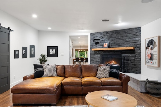 1254 S Church St, Georgetown, TX 78626 - living room with wood finished floors, a barn door, a stone fireplace, and recessed lighting
