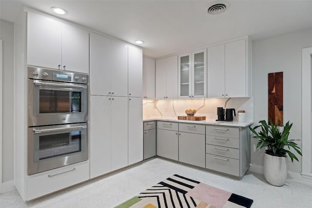 1254 S Church St, Georgetown, TX 78626 - kitchen with double oven, light countertops, glass insert cabinets, white cabinetry, and recessed lighting