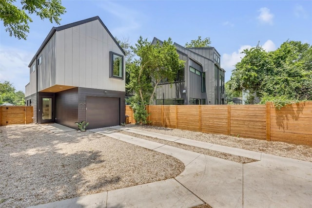 3409 Neal St Unit 2, Austin, TX 78702 - view of side of property featuring an attached garage, concrete driveway, and fence