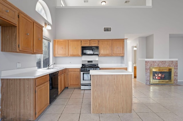 16901 Dashwood Creek Dr, Pflugerville, TX 78660 - kitchen with black appliances, light tile patterned floors, light countertops, and a high ceiling
