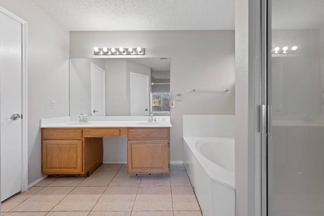 16901 Dashwood Creek Dr, Pflugerville, TX 78660 - bathroom featuring a garden tub, double vanity, tile patterned floors, a stall shower, and a textured ceiling