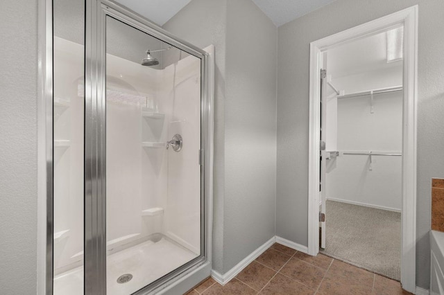 141 Snowy Egret Ln, Leander, TX 78641 - full bathroom featuring a stall shower, a spacious closet, baseboards, and tile patterned floors
