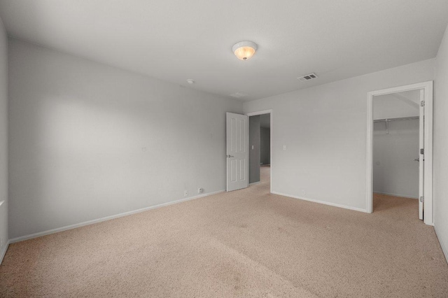 141 Snowy Egret Ln, Leander, TX 78641 - unfurnished bedroom with light colored carpet, a walk in closet, baseboards, and a closet