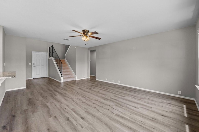 141 Snowy Egret Ln, Leander, TX 78641 - unfurnished living room featuring stairs, a ceiling fan, wood finished floors, and baseboards