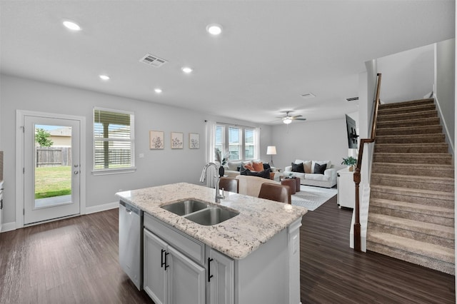142 Dome Peak Ter, Dripping Springs, TX 78620 - kitchen with dishwasher, dark wood-type flooring, a center island with sink, ceiling fan, and light stone counters
