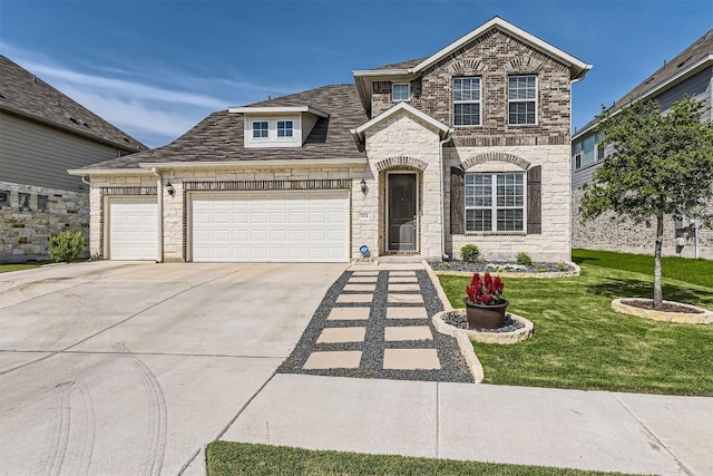 206 Monteforte Rd, Hutto, TX 78634 - view of front of home with driveway, an attached garage, a front yard, and stone siding