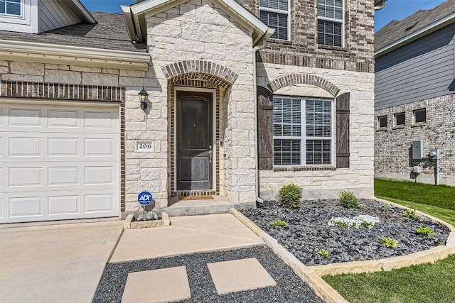 206 Monteforte Rd, Hutto, TX 78634 - property entrance featuring stone siding, concrete driveway, and an attached garage