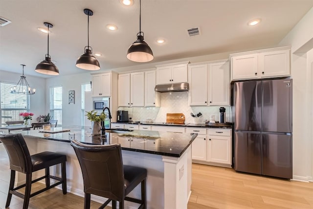 206 Monteforte Rd, Hutto, TX 78634 - kitchen featuring stainless steel appliances, under cabinet range hood, recessed lighting, white cabinetry, and backsplash