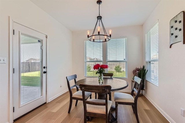 206 Monteforte Rd, Hutto, TX 78634 - dining room with light wood-style flooring, a chandelier, and baseboards