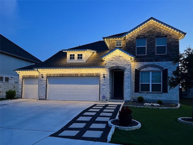 206 Monteforte Rd, Hutto, TX 78634 - view of front of house with a front yard, concrete driveway, a garage, and stone siding