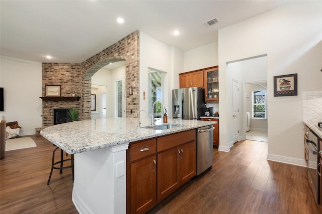 152 Baretta Loop, Buda, TX 78610 - kitchen with a sink, stainless steel appliances, a brick fireplace, open floor plan, and dark wood finished floors