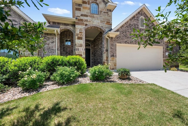 152 Baretta Loop, Buda, TX 78610 - view of front of property featuring brick siding, concrete driveway, an attached garage, stone siding, and a front yard