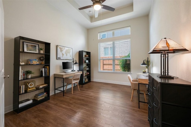 152 Baretta Loop, Buda, TX 78610 - home office with dark wood-style floors, ceiling fan, a tray ceiling, and baseboards