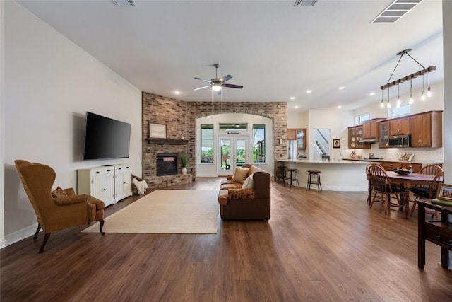 152 Baretta Loop, Buda, TX 78610 - living room with dark wood-style floors, a brick fireplace, ceiling fan, recessed lighting, and baseboards