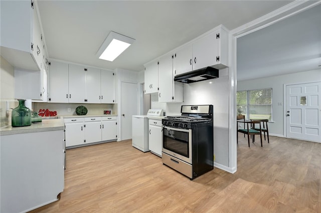1408 Kent St, Taylor, TX 76574 - kitchen with stainless steel range with gas cooktop, washer / dryer, under cabinet range hood, light countertops, and light wood-type flooring