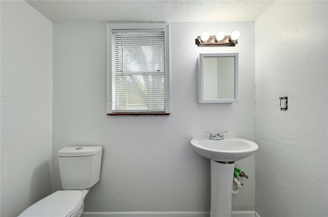 1408 Kent St, Taylor, TX 76574 - bathroom featuring toilet, a textured ceiling, and baseboards