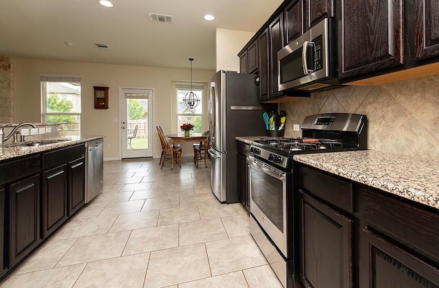 112 Moulins Ln, Georgetown, TX 78626 - kitchen featuring appliances with stainless steel finishes, a sink, decorative backsplash, recessed lighting, and light stone counters