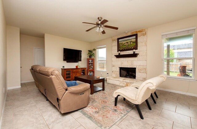 112 Moulins Ln, Georgetown, TX 78626 - living room featuring a ceiling fan, light tile patterned floors, and a stone fireplace