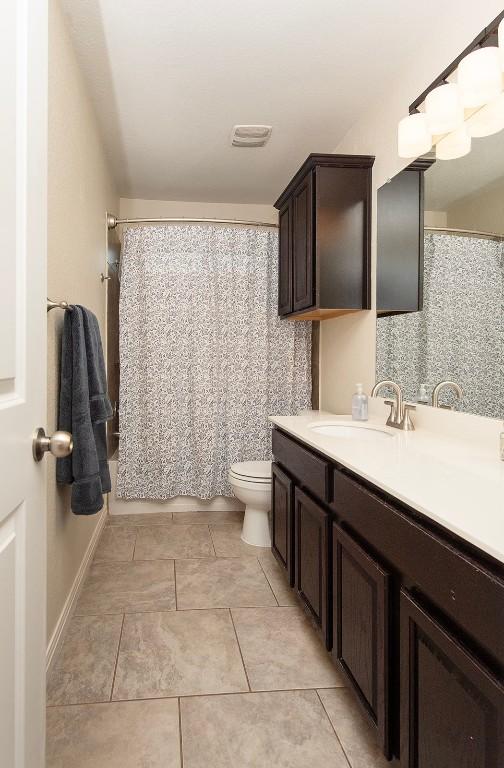 112 Moulins Ln, Georgetown, TX 78626 - full bath featuring toilet, vanity, tile patterned floors, and a shower with shower curtain